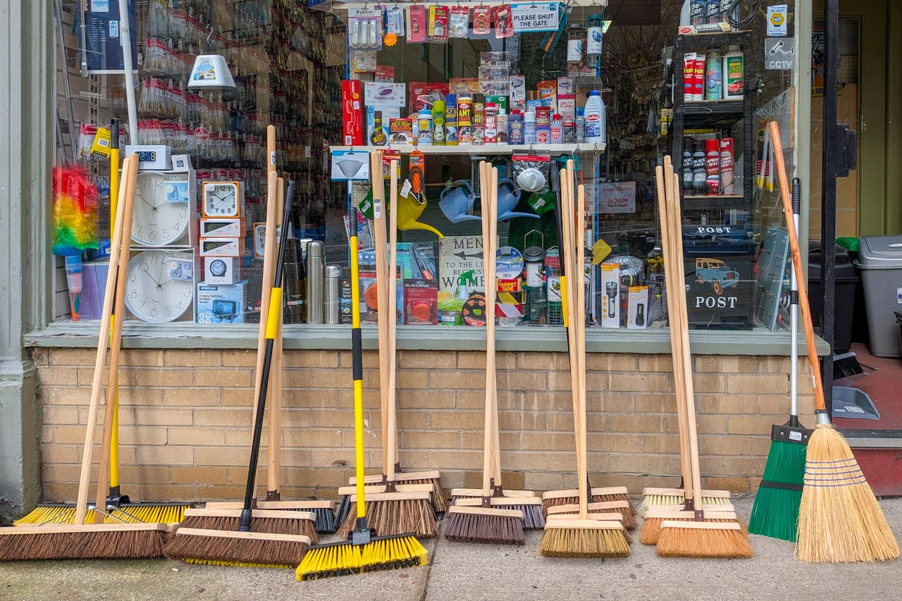 A variety of brooms displayed outside a hardware store in Harrogate, England.